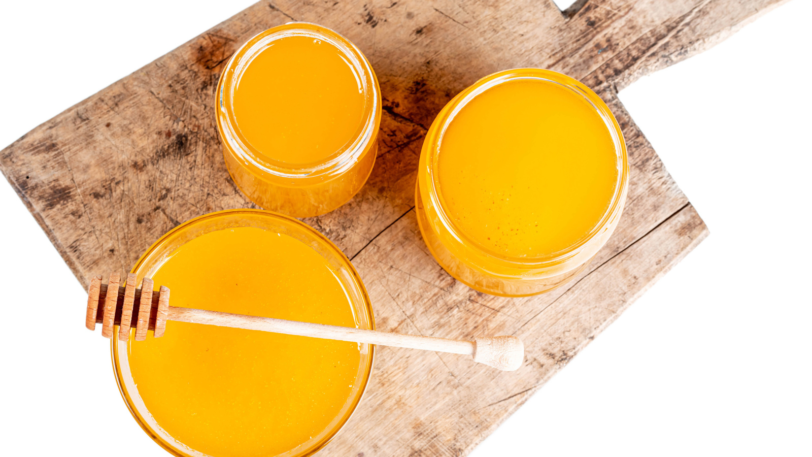Свежий мед в банках на деревянной доске на белом фоне