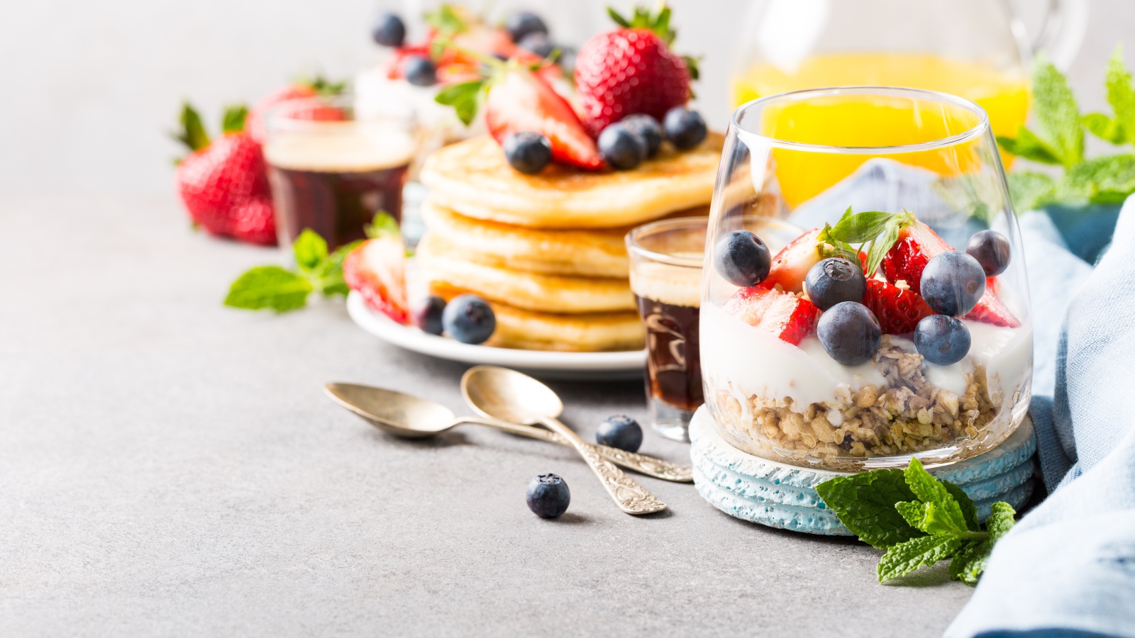 Оладьи на столе с ягодами, мюсли и кофе