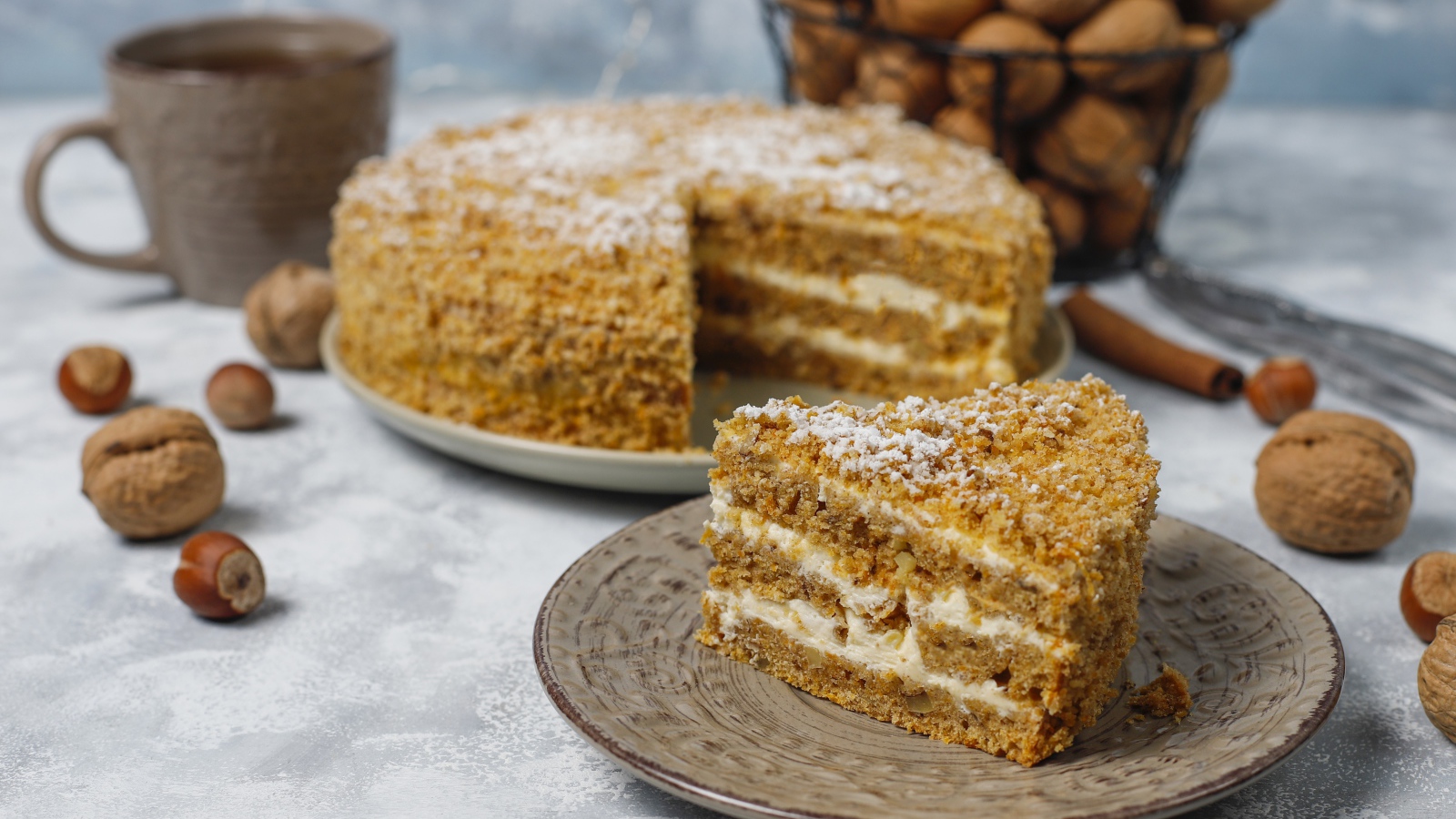 Торт медовик на столе с орехами и чашкой кофе