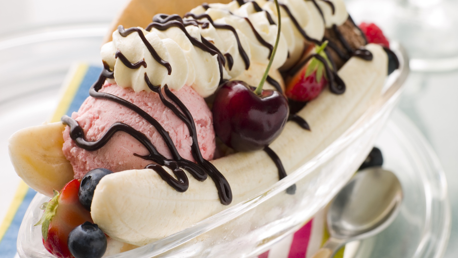 Шарики мороженого на тарелке с бананами и черешней 