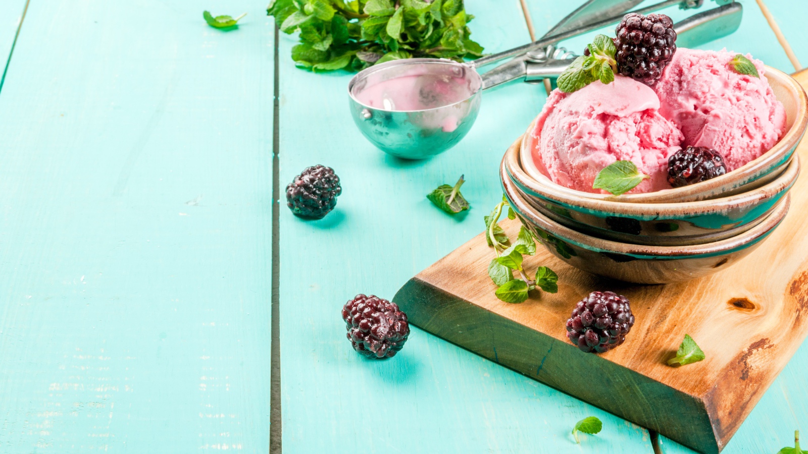 Шарики мороженого на столе с ягодами черники и мятой
