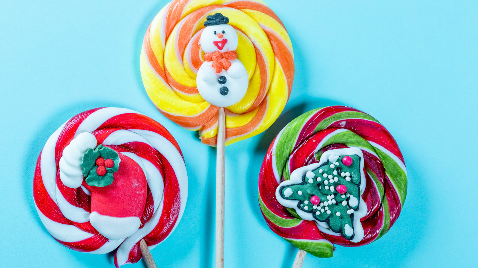 Разноцветные леденцы на палочках на голубом фоне