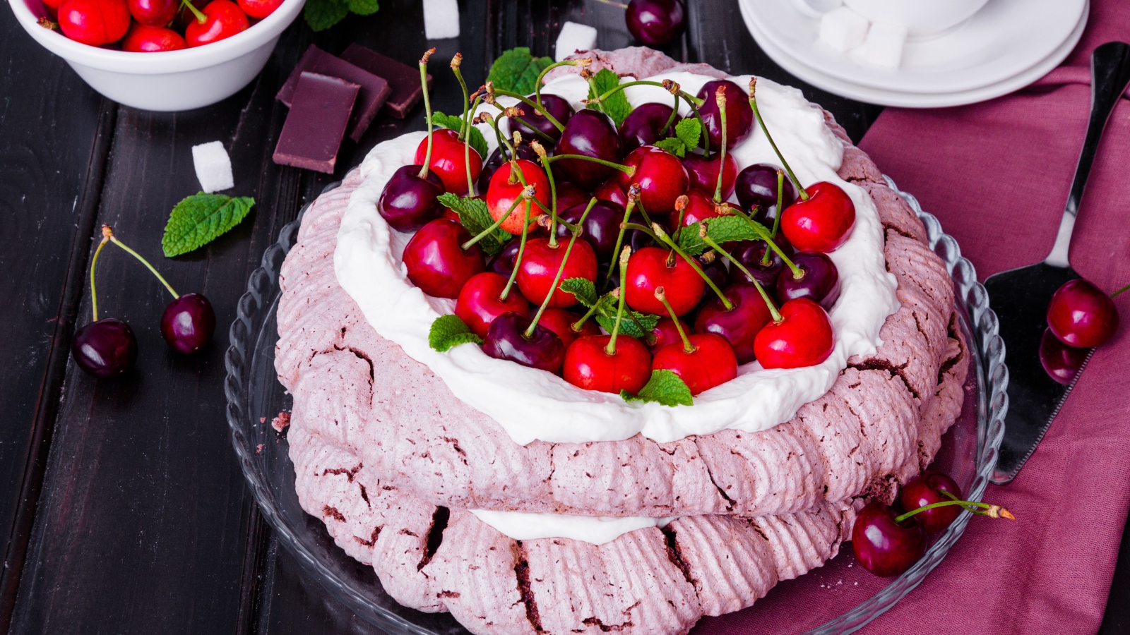 Торт Павлова со сливками и ягодами черешни на столе