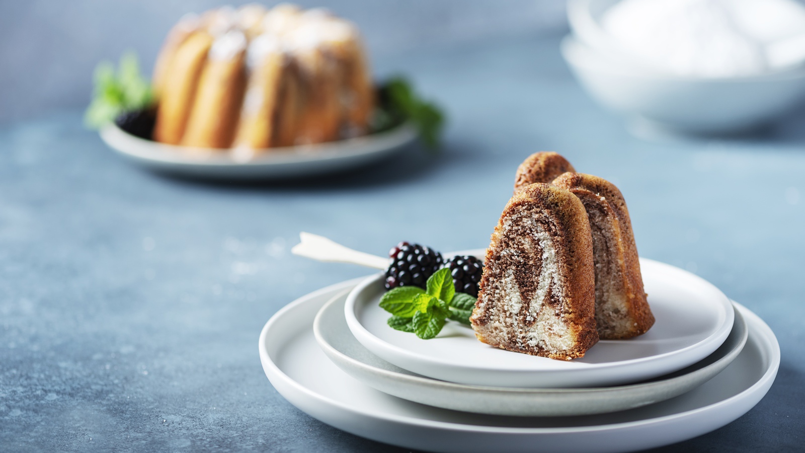 Кусочки кекса на тарелке с ягодами ежевики