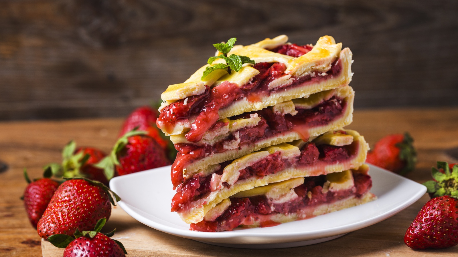 Пирог с ягодами клубники на белой тарелке 