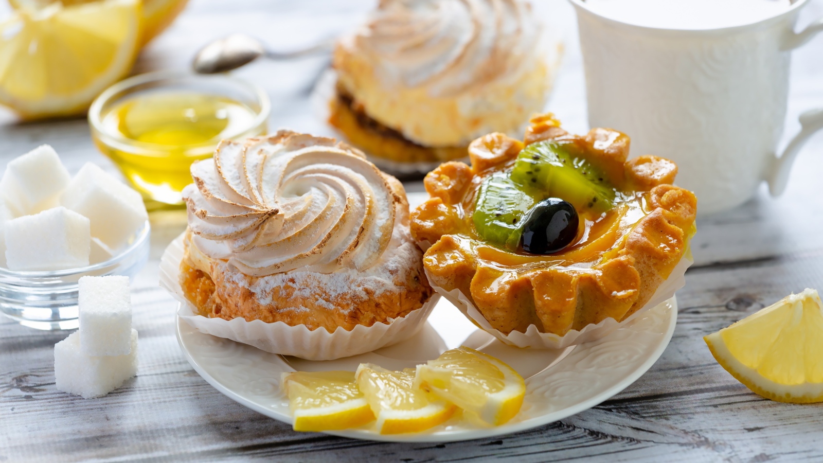Вкусные аппетитные пирожные на тарелке с лимоном