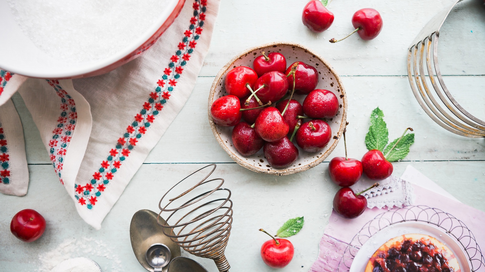 Wet cherries on a table with a cake
