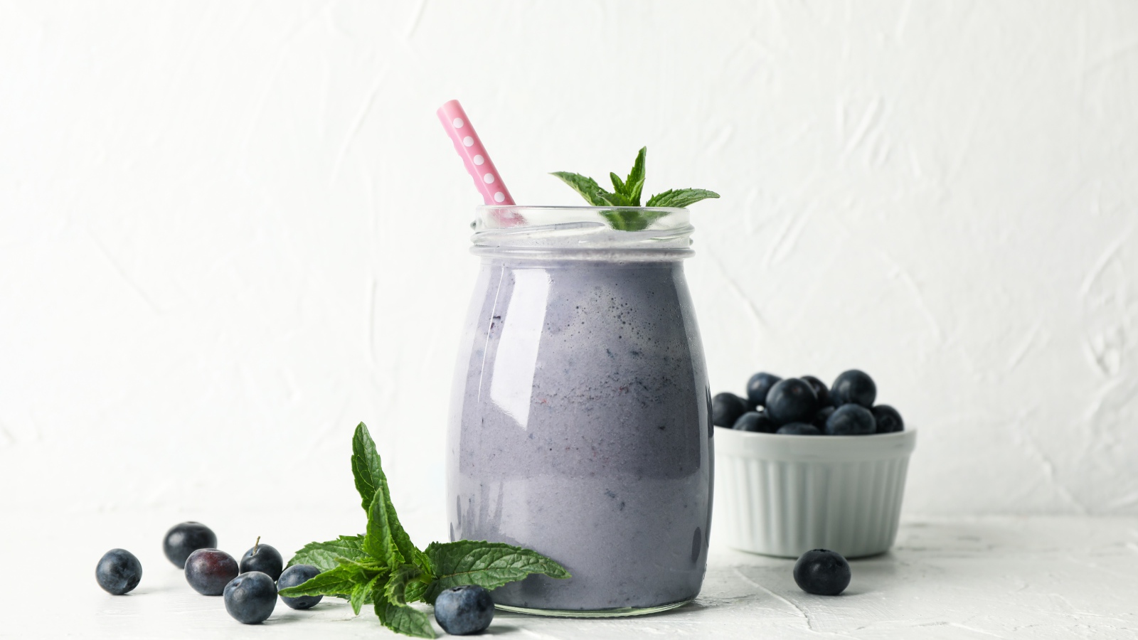 Черничный смузи в банке с мятой и свежими ягодами