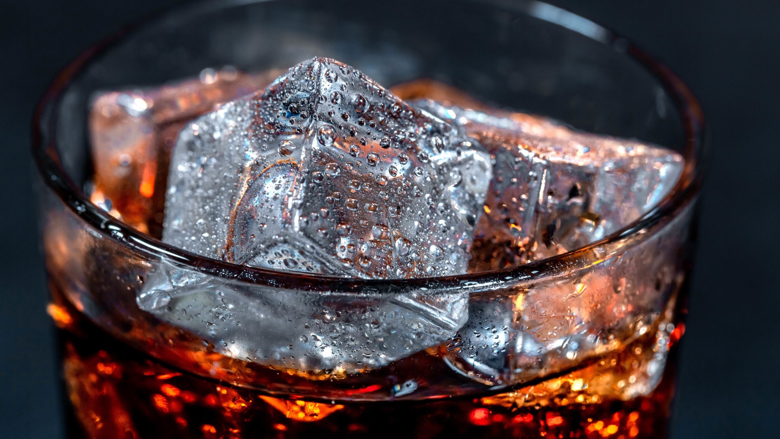 Напиток кока кола в стакане с кубиками льда