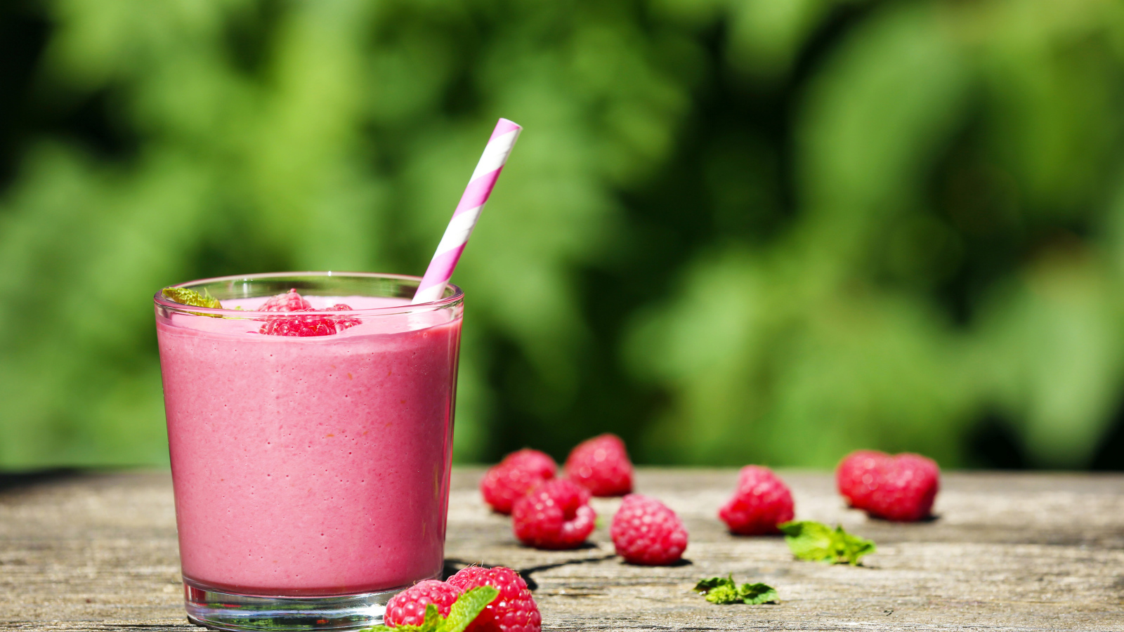 Коктейль в стакане с трубочкой и ягодами малины