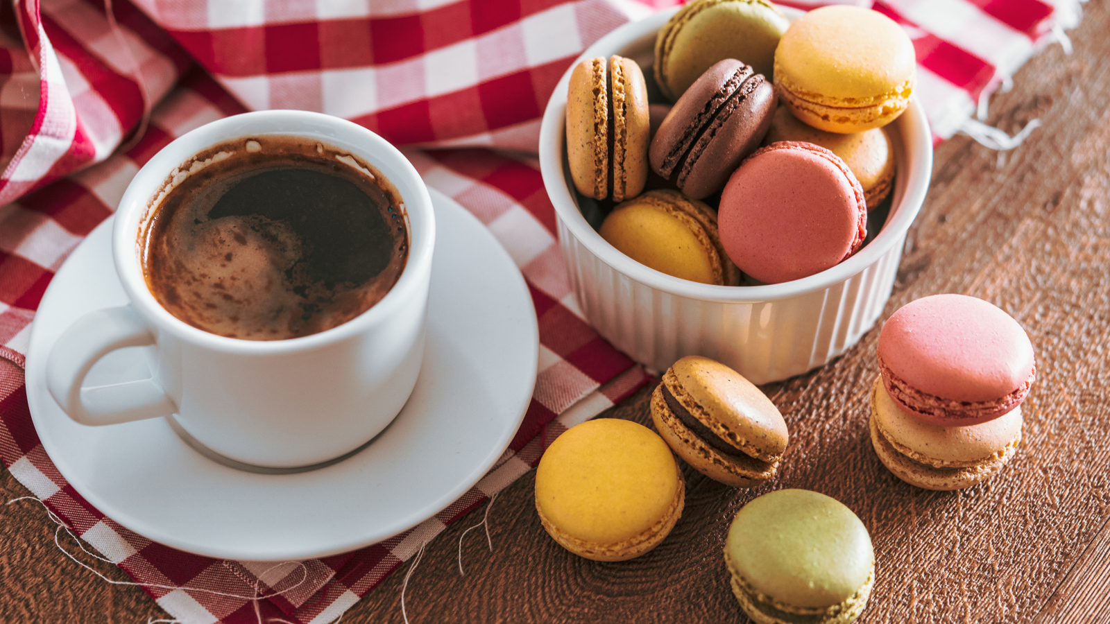 Чашка кофе на столе с десертом макарун 