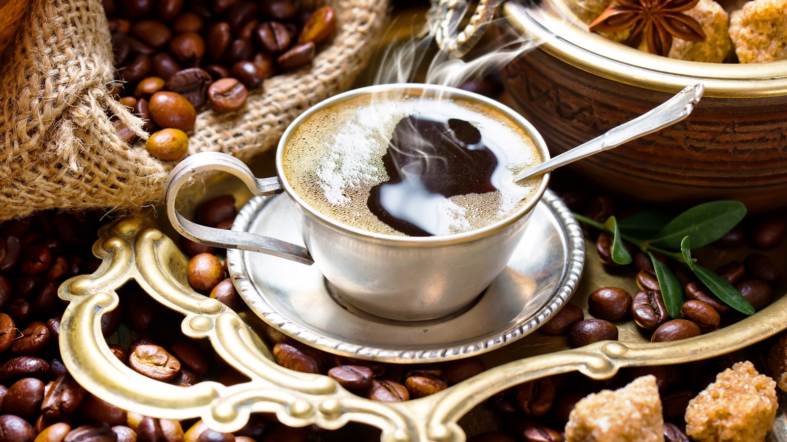 Чашка горячего вкусного кофе на столе с зернами