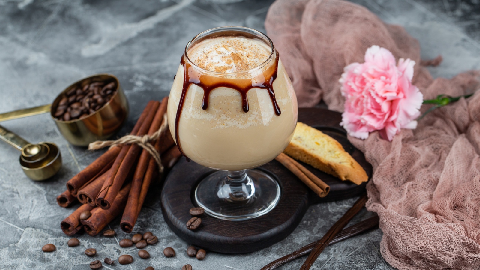Вкусный кофейный напиток на столе с корицей и гвоздикой