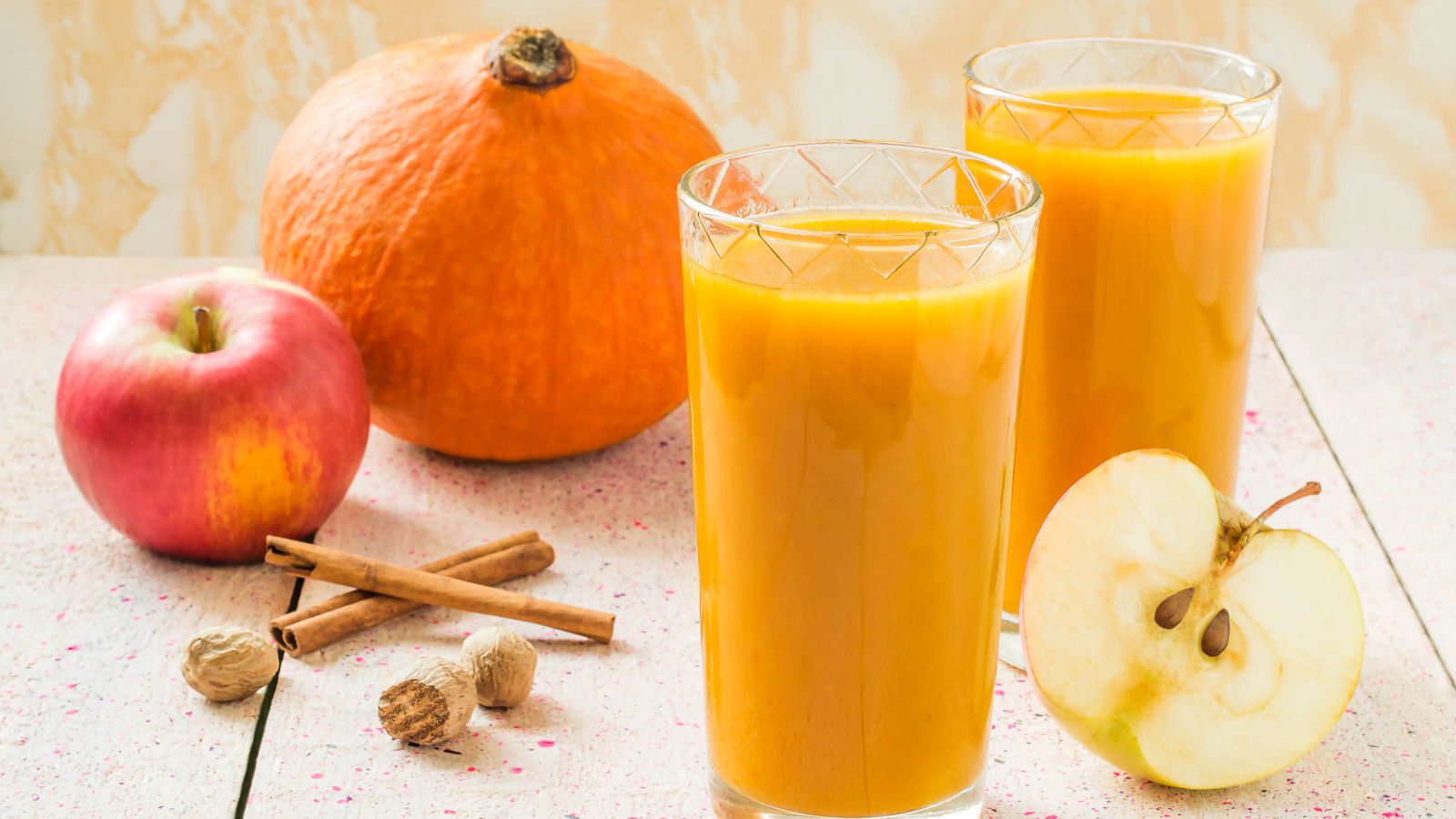 Свежевыжатый сок в стаканах на столе с фруктами