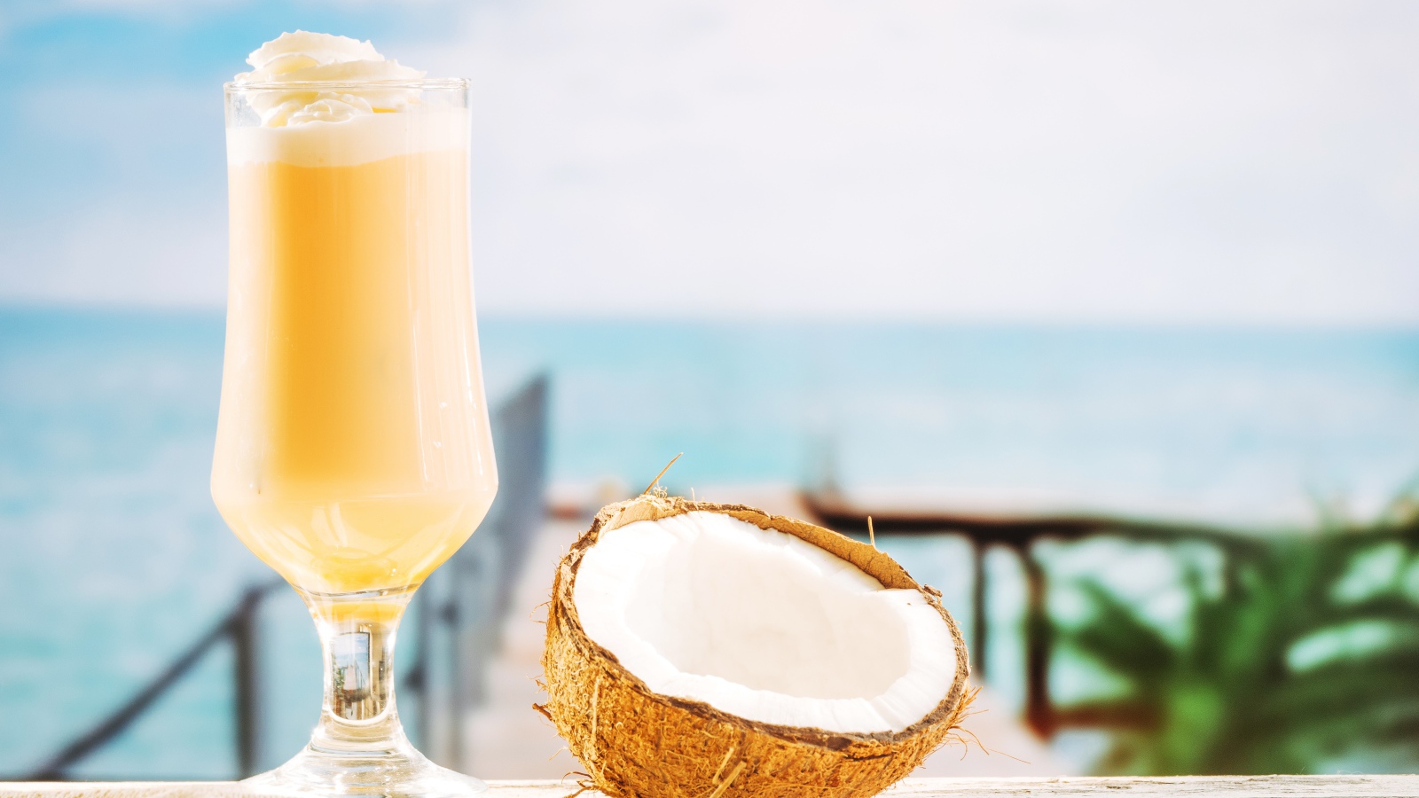 Стакан с коктейлем на столе с кокосом 