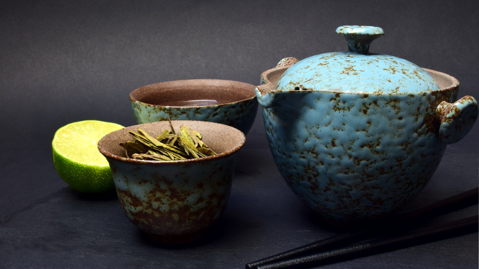 Зеленый чай на столе с посудой и лаймом