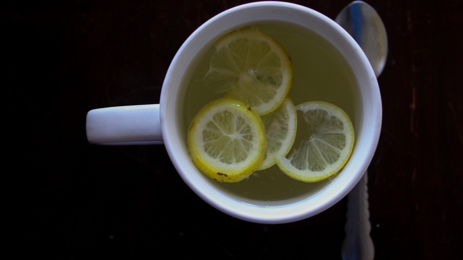 Зеленый чай с лимоном на черном фоне