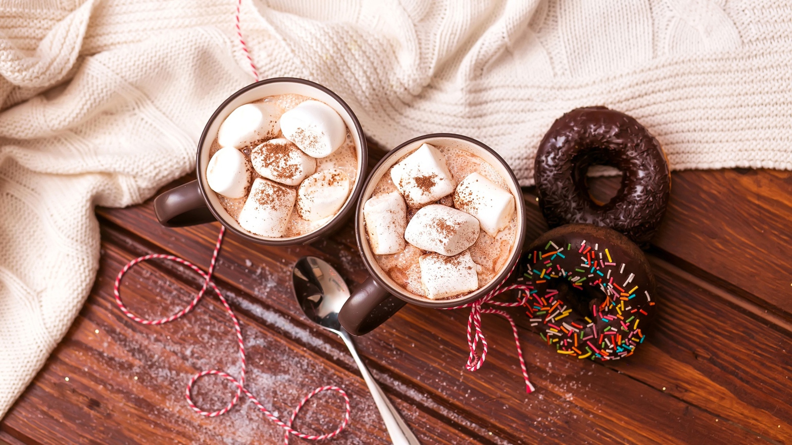 Горячий какао с маршмеллоу с пончиками на столе 