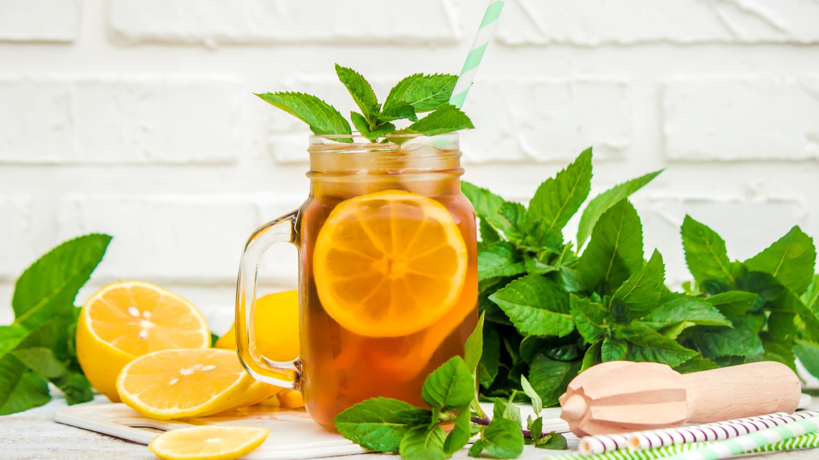 Лимонад на столе с лимоном и листьями мяты 
