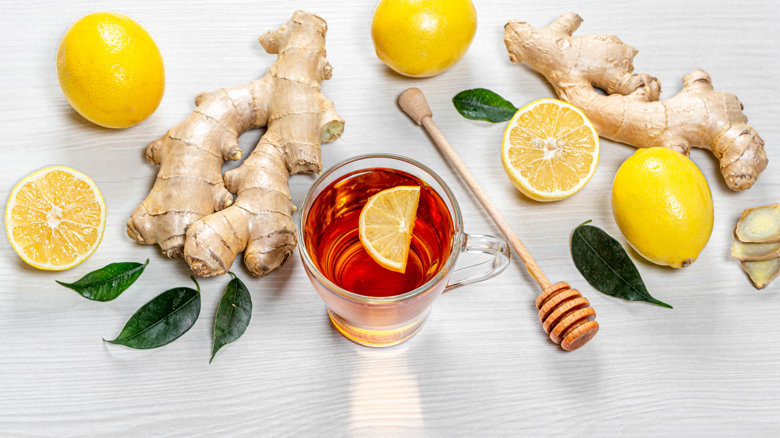 Чай в стеклянной чашке на столе с лимоном и имбирем 