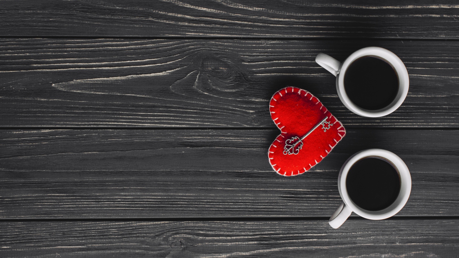 Две чашки кофе на столе с сердцем и ключом