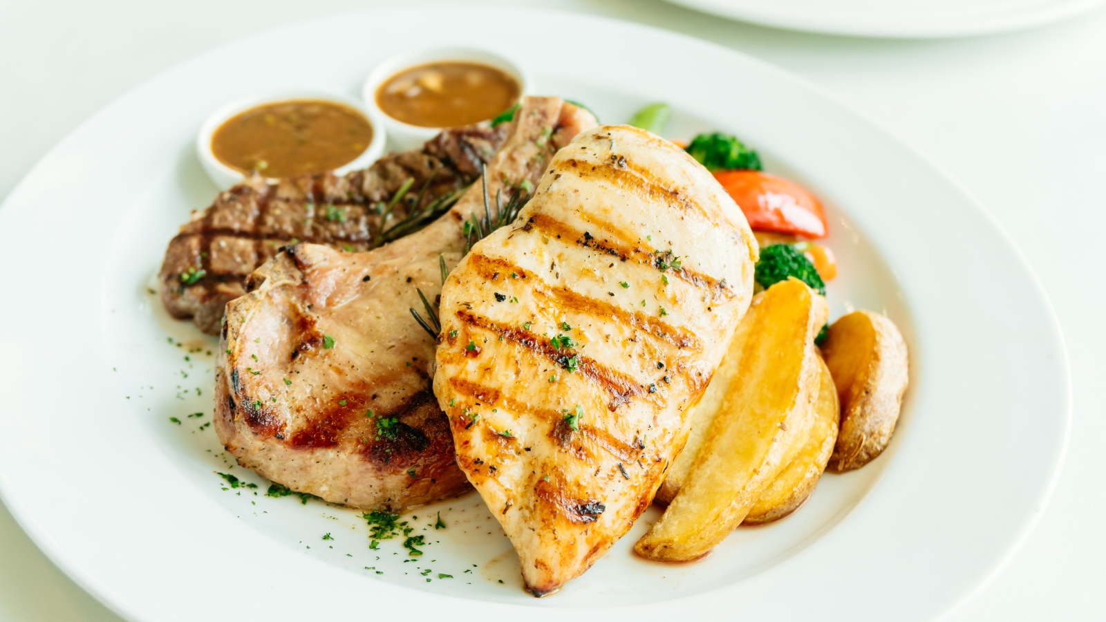 Запеченное мясо гриль на тарелке с овощами