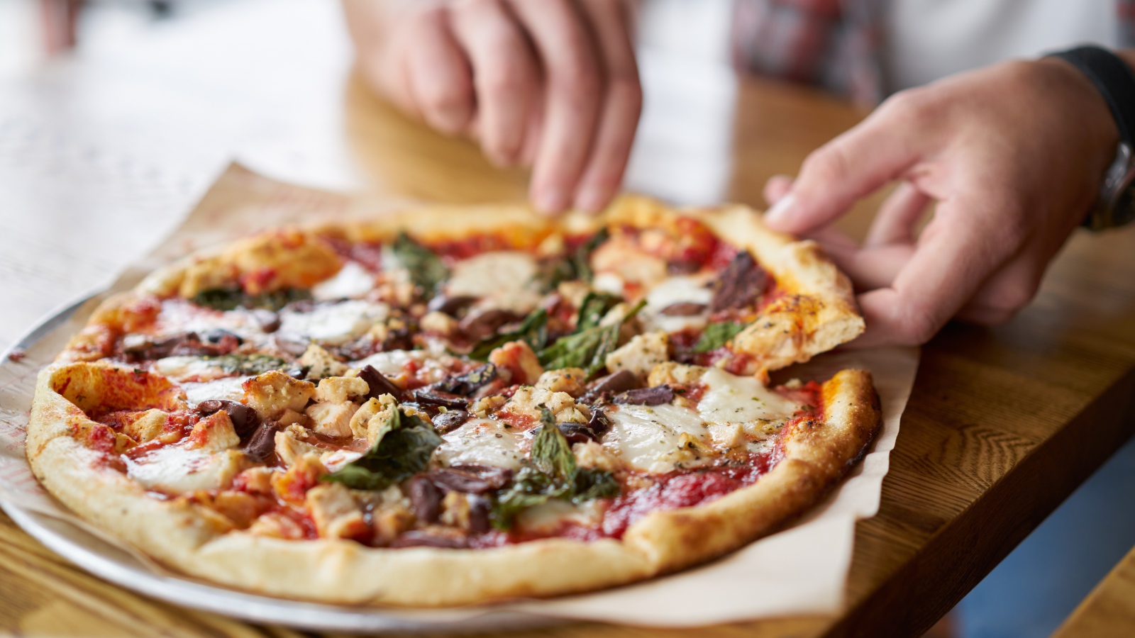 Мужчина в кафе ест вкусную горячую пиццу 