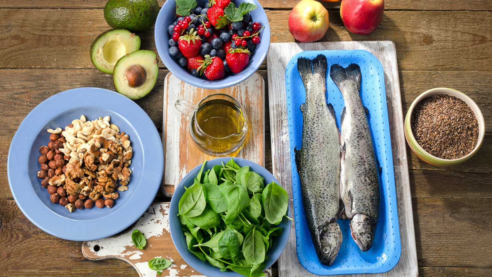 Fresh fish on a table with nuts, basil and berries