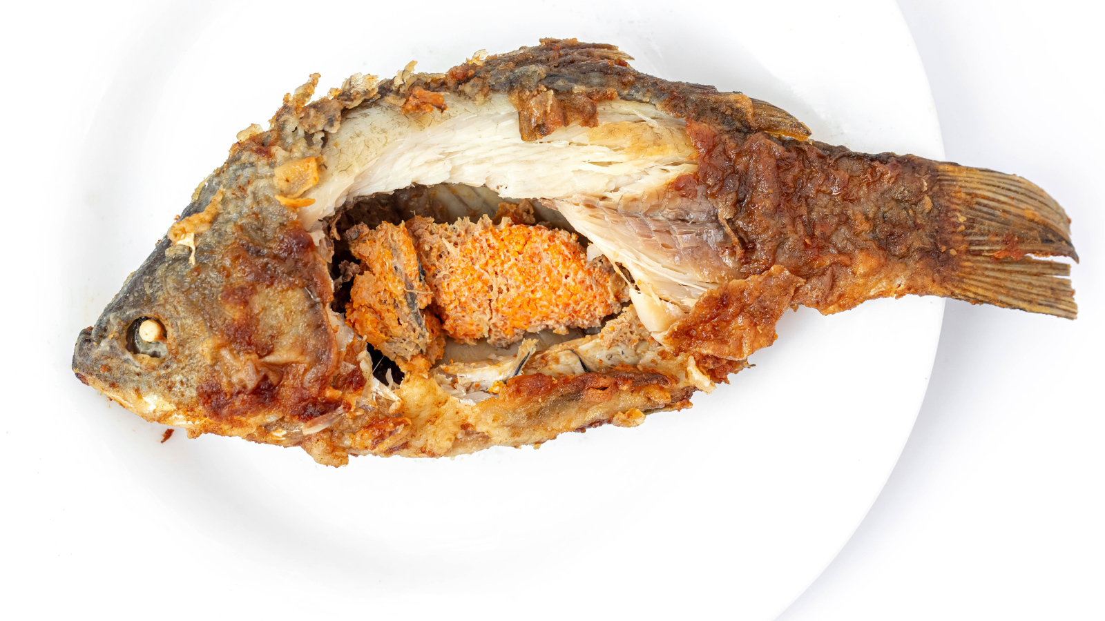 Жареная рыба с икрой внутри на белом фоне