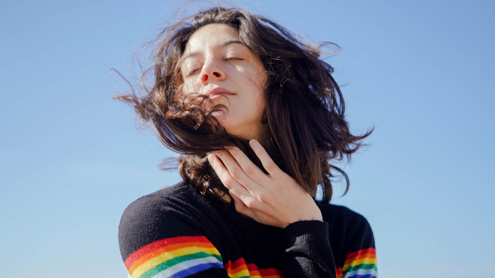 Молодая девушка греет лицо на солнце