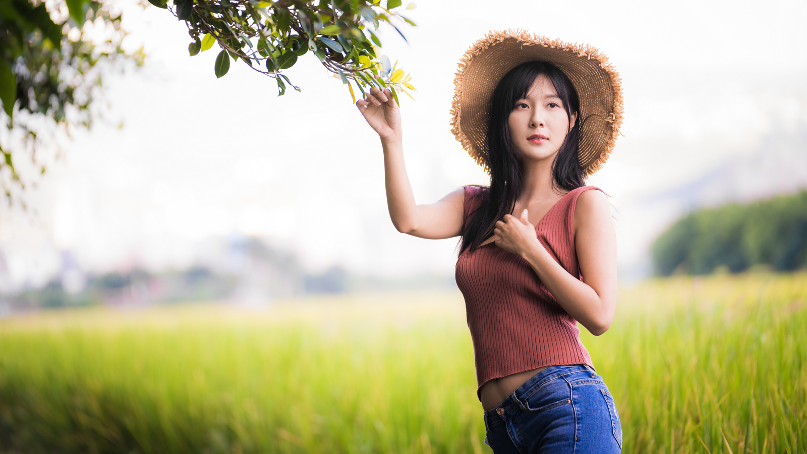 Девушка азиатка в шляпе на поле 