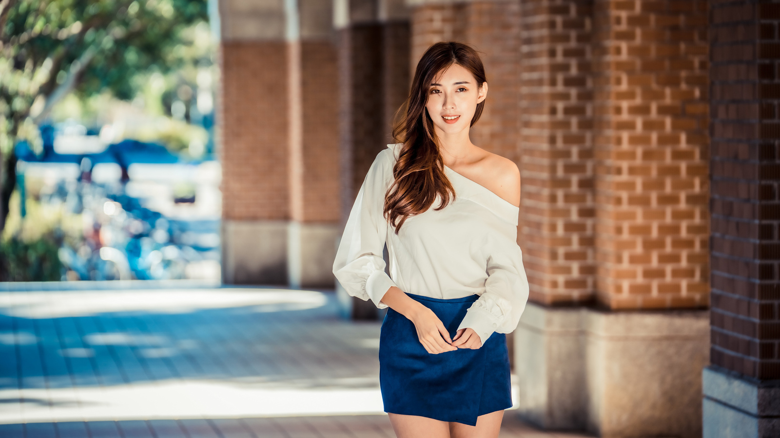 Девушка азиатка в короткой юбке у стены