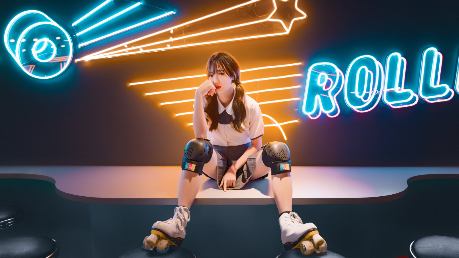 Девушка азиатка сидит в роликах на фоне вывески 