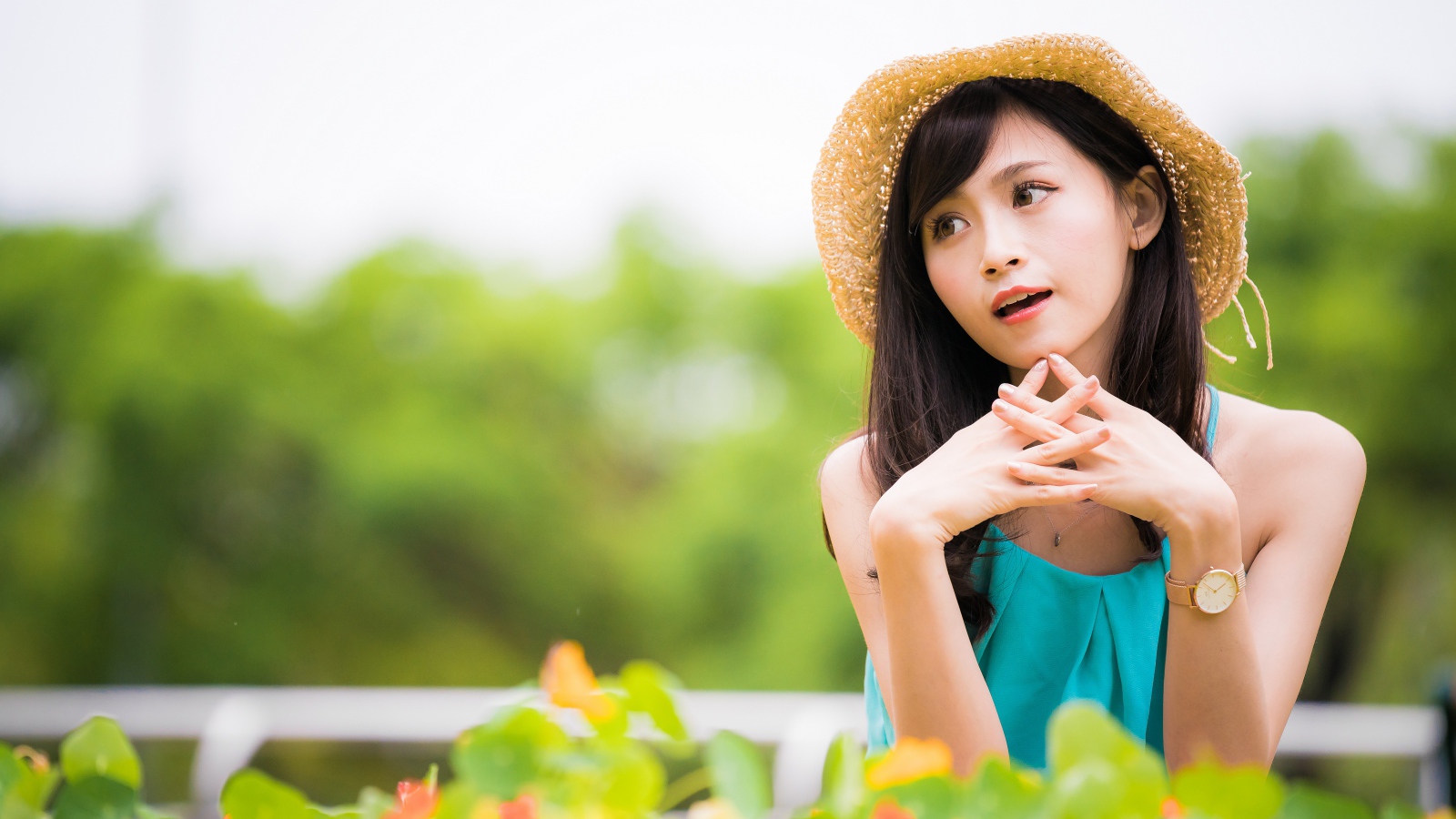 Девушка азиатка с часами на руке в шляпе