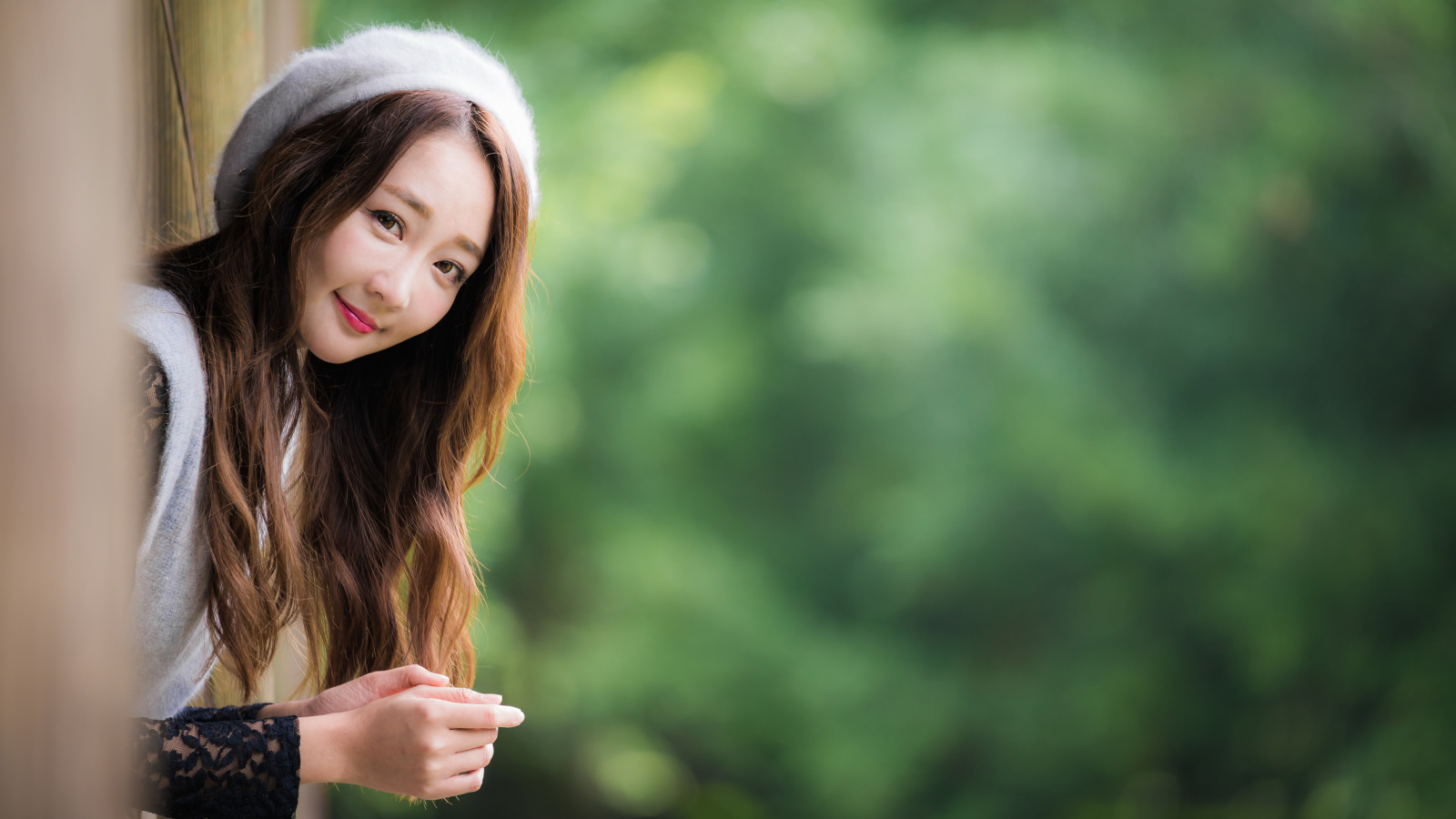 Азиатка в берете выглядывает из окна