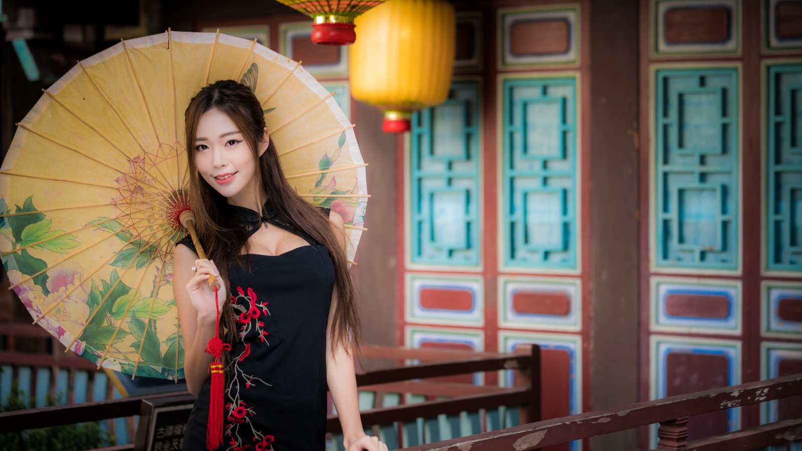 Красивая девушка азиатка в черном платье с зонтом