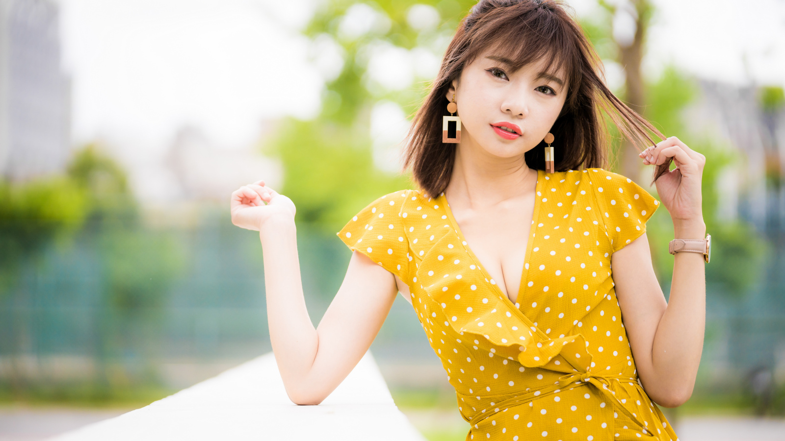 Красивая азиатка в желтом платье в белый горох 