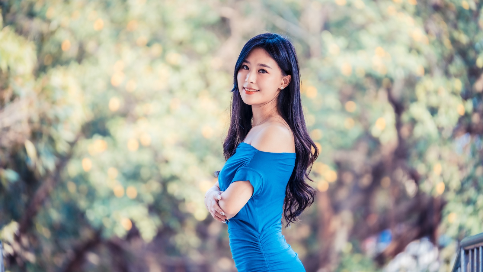 Красивая девушка азиатка с милой улыбкой в голубом платье 