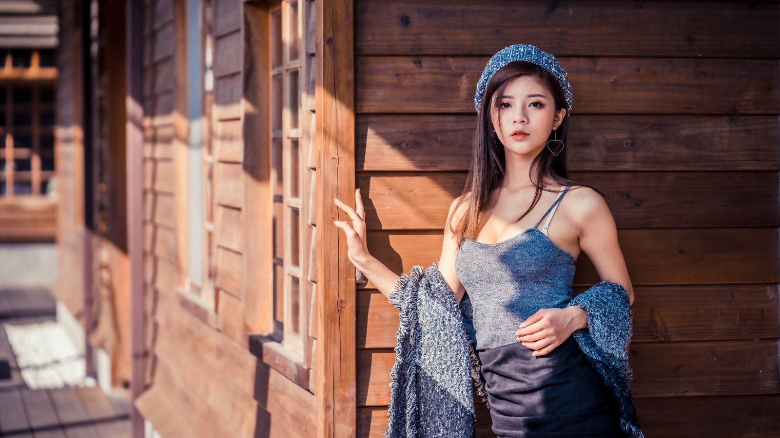 Красивая девушка азиатка стоит у деревянной стены 