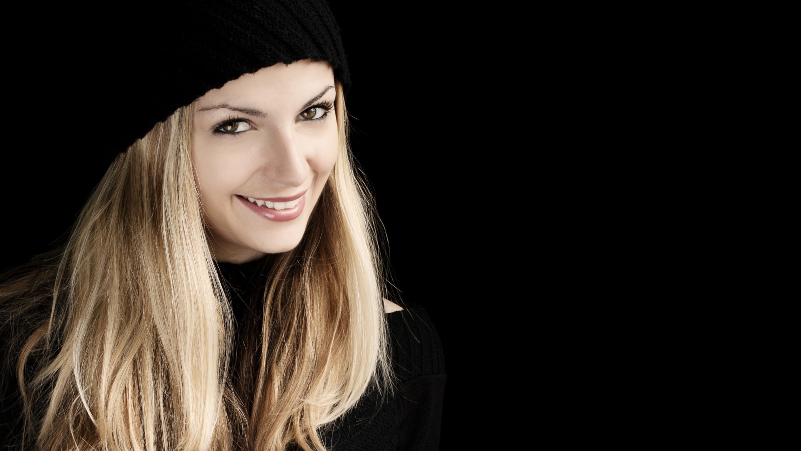 Красивая блондинка в шапке на черном фоне