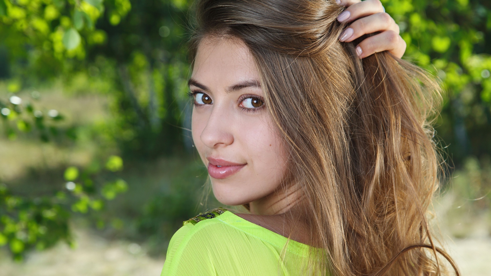 Красивая кареглазая шатенка с рукой в волосах 
