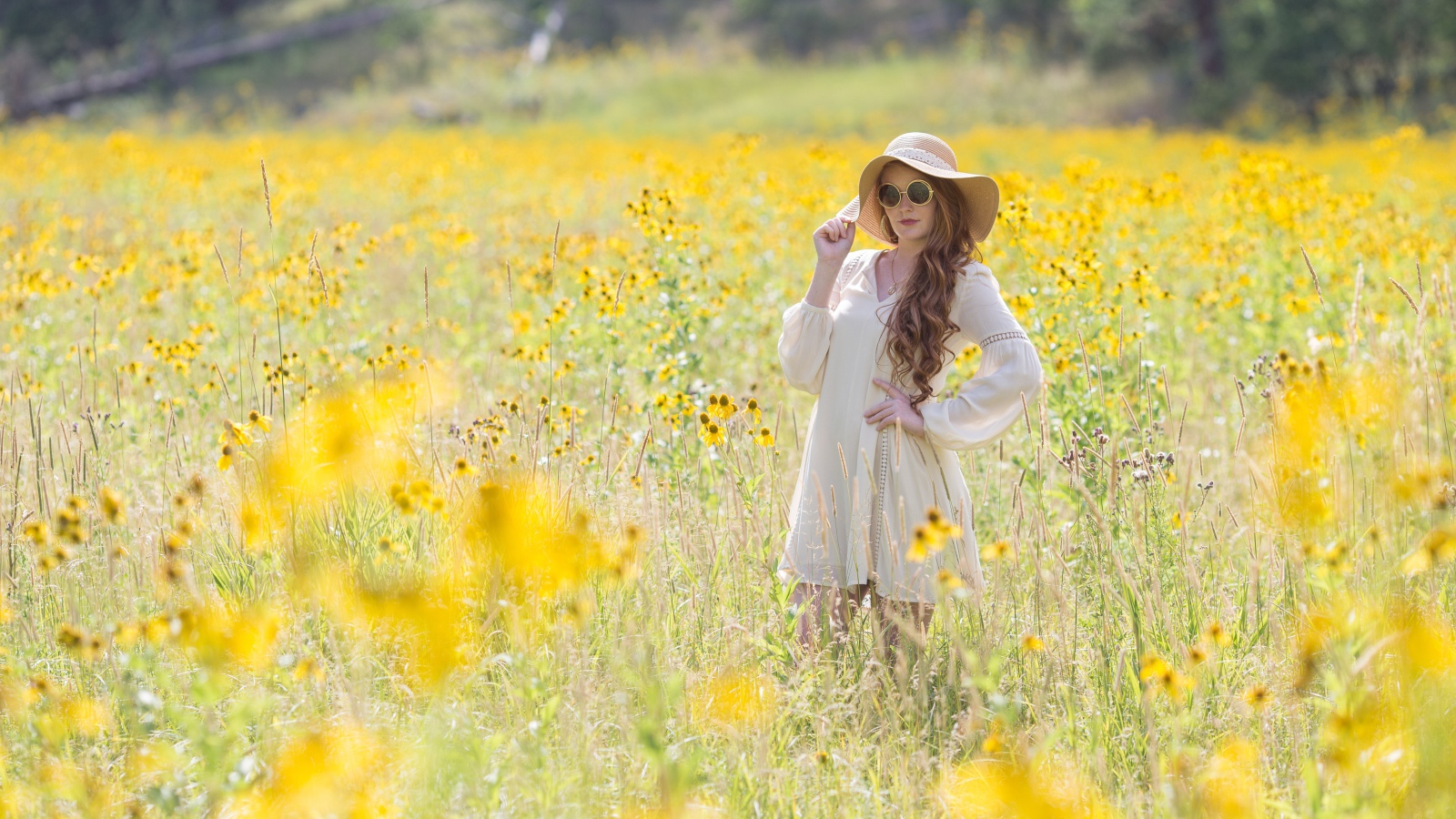 Красивая девушка в шляпе на поле с желтыми цветами
