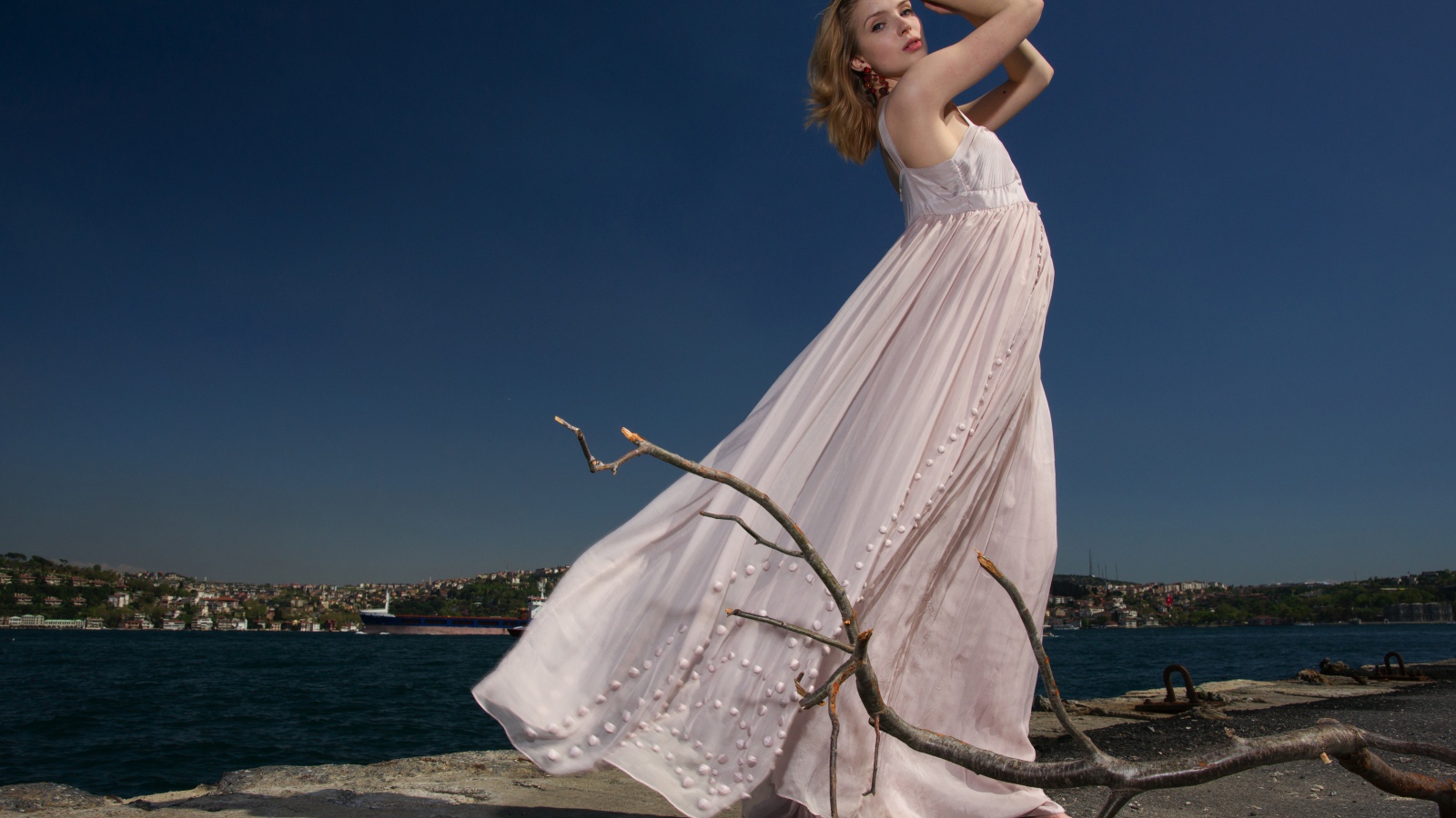 Красивая девушка в белом платье на берегу реки