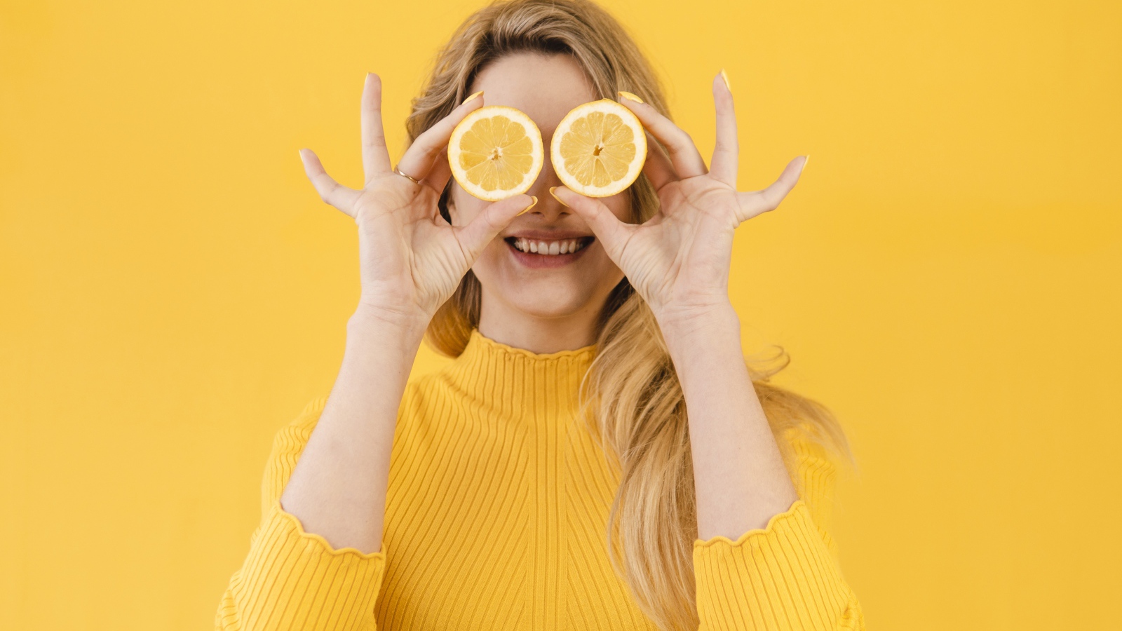 Красивая девушка в желтом свитере с лимоном