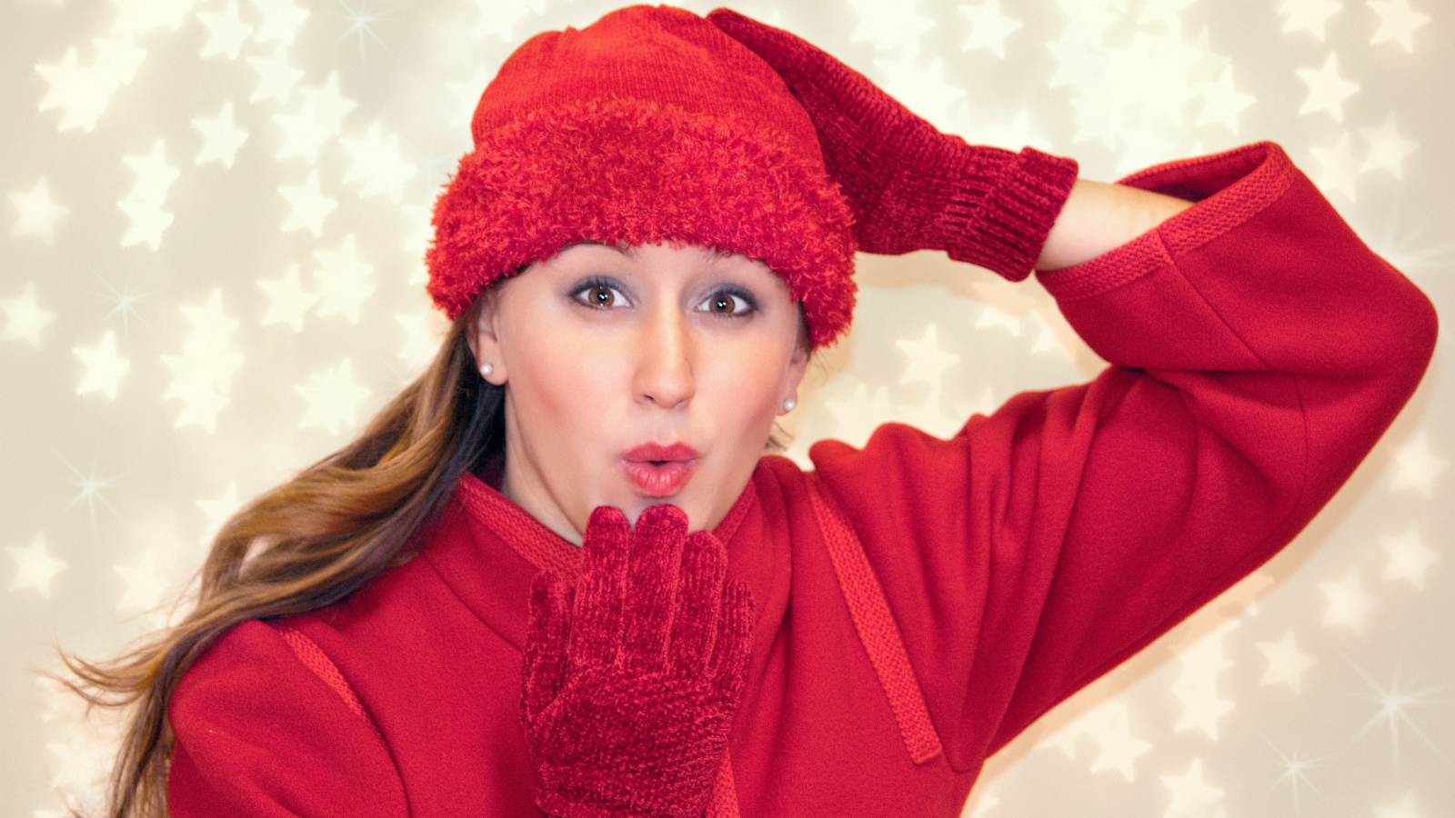 Красивая девушка в красном шлет воздушный поцелуй