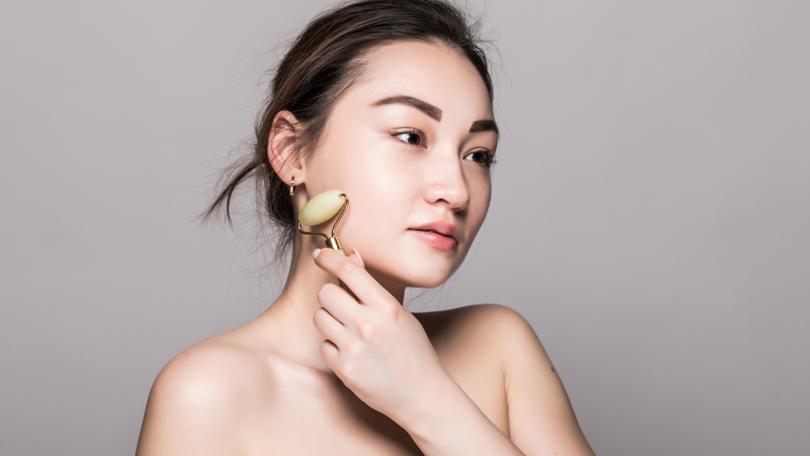 Красивая девушка разглаживает кожу лица