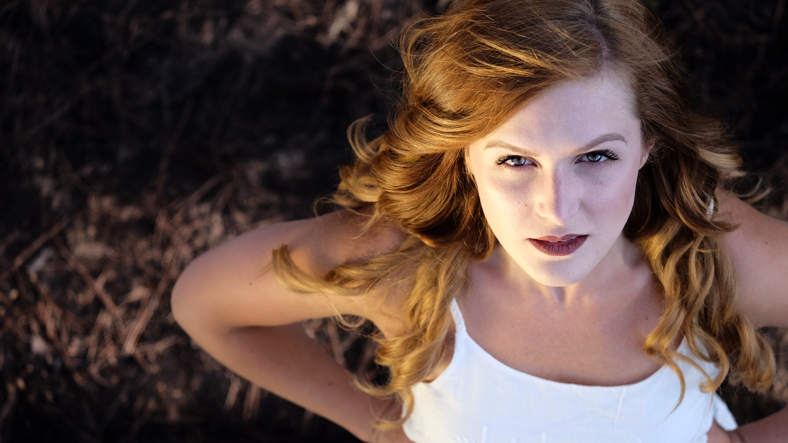 Красивый взгляд рыжеволосой девушки в белом платье