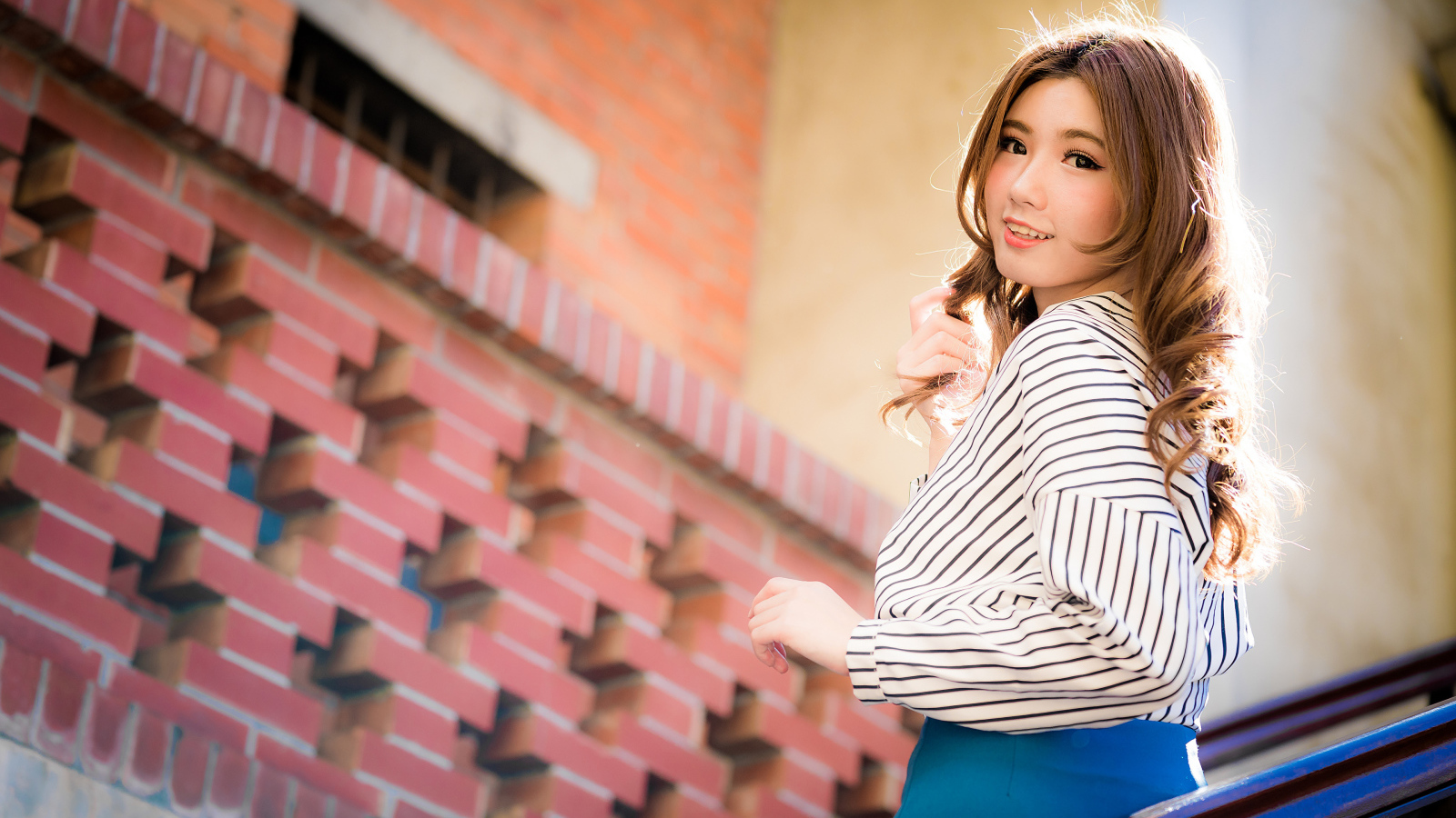 Красивая улыбающаяся азиатка стоит на лестнице 