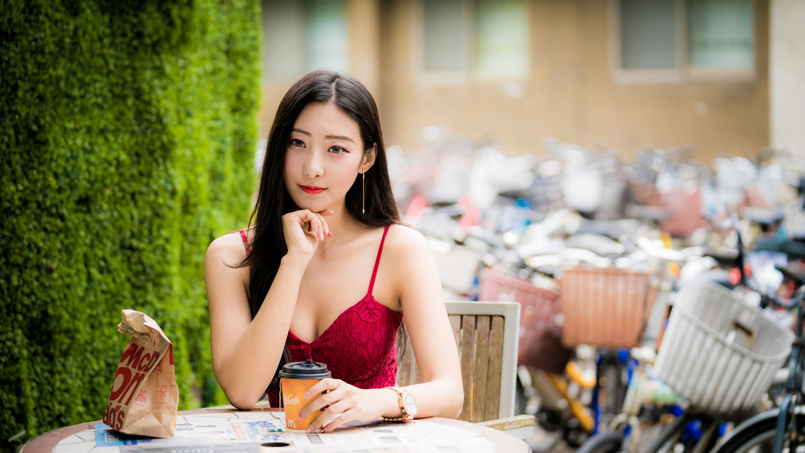 Милая девушка азиатка сидит за столиком в кафе