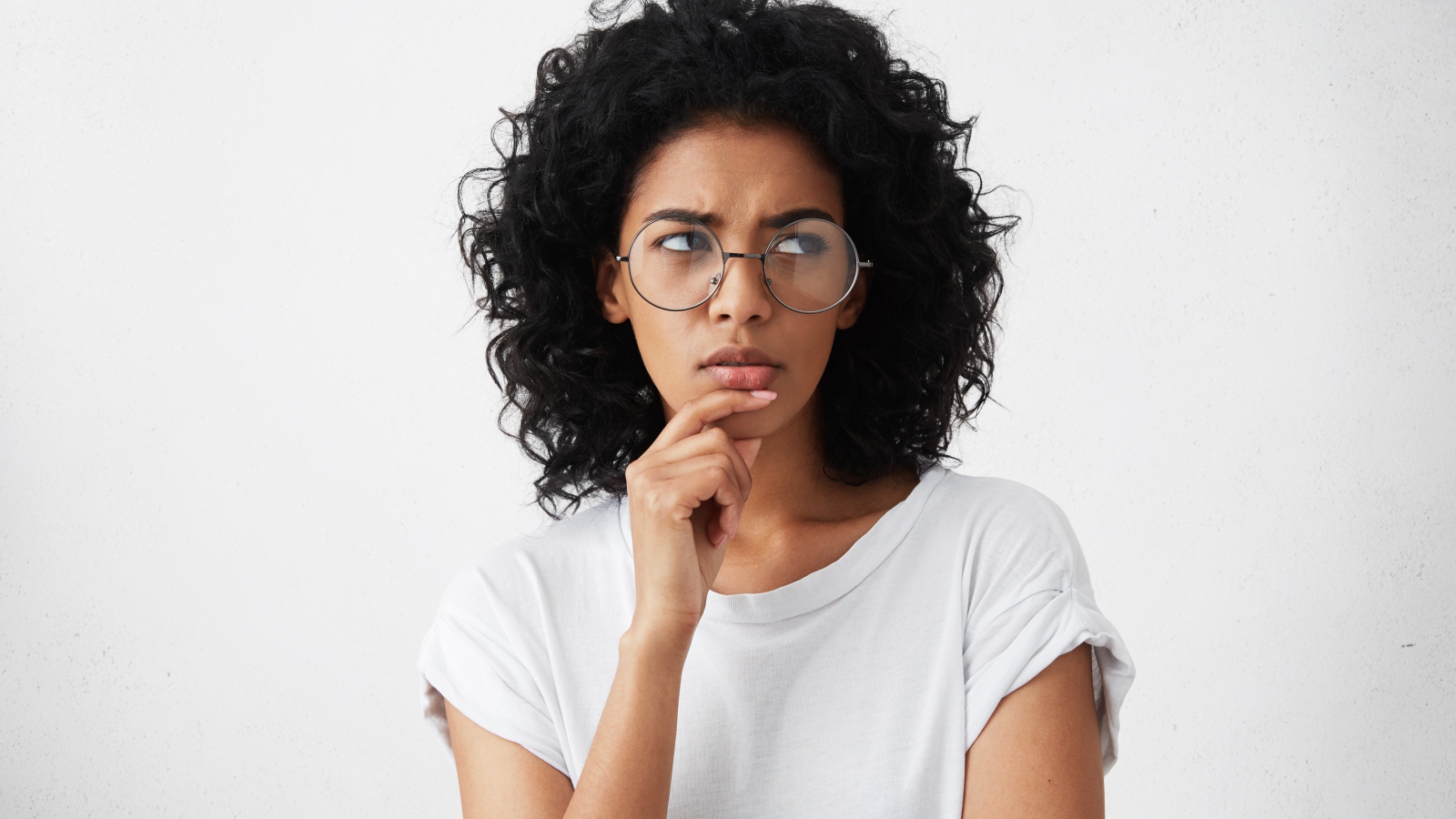 Темноволосая девушка в очках на сером фоне